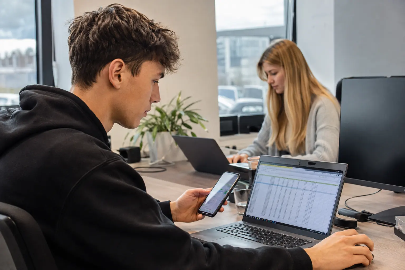 Informatik-Kaufmann bespricht Zahlen am Laptop