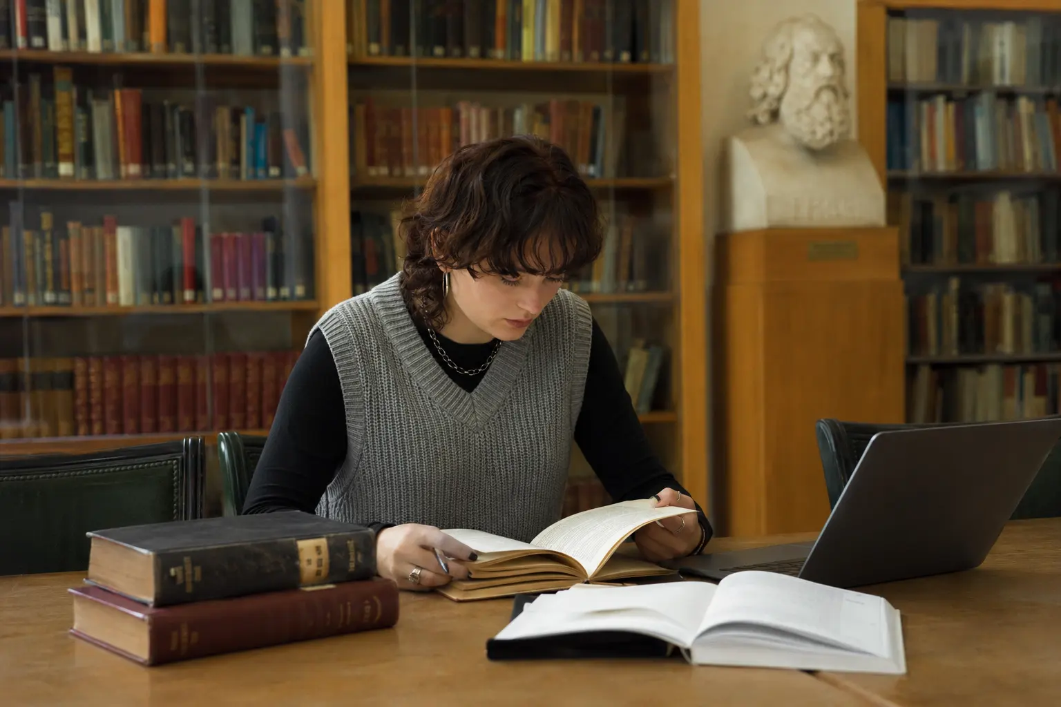 Studentin liest in alten Bänden in der Bibliothek