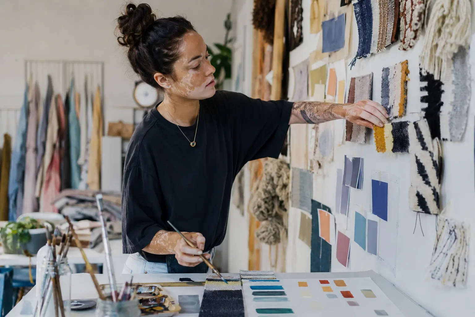 Textildesignerin ordnet Stoffmuster an der Musterwand