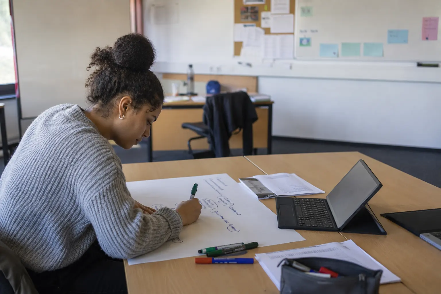 Studentin arbeitet an Unterlagen in einem Seminarraum